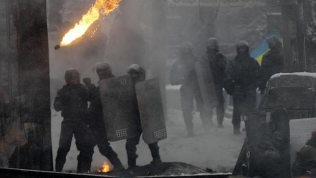 Under fire: a petrol bomb flies over the heads of riot police in Kiev on Wednesday.