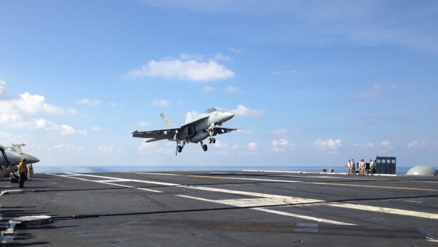 A jet fighter takes off on a US aircraft carrier in the South China Sea.