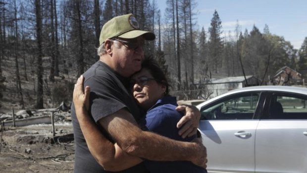 Jim Taylor hugs lifelong friend, Mary Mazzoni, in in Weed, California. Taylor's home was one of three on his street that survived the Boles Fire. 