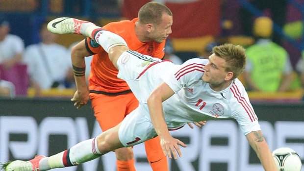 Dutch defender John Heitinga tangles Danish forward Nicklas Bendtner.