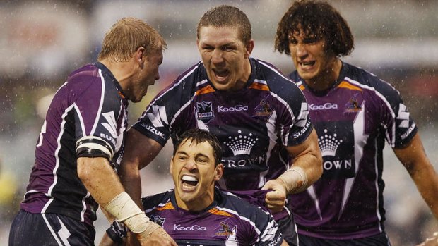Centre of attention: Billy Slater celebrates with teammates after scoring a try against the Raiders.