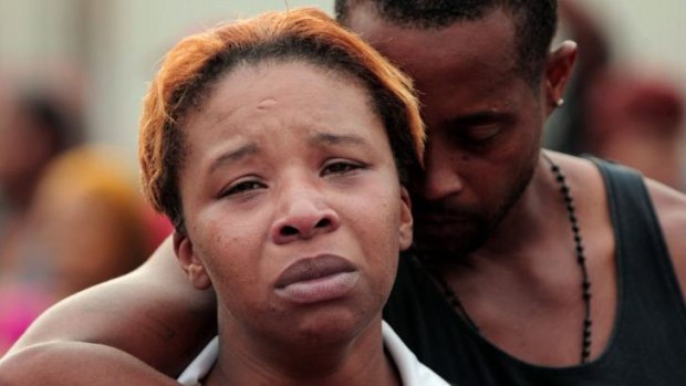 Lesley McSpadden, left, is comforted by her husband, Louis Head, after her 18-year-old son, Michael Brown was shot and killed by police in the middle of the street in Ferguson, Missouri, near St Louis on Saturday.