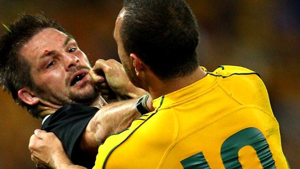 Richie McCaw of the All Blacks wrestles with Quade Cooper of the Wallabies during the Tri Nations decider.