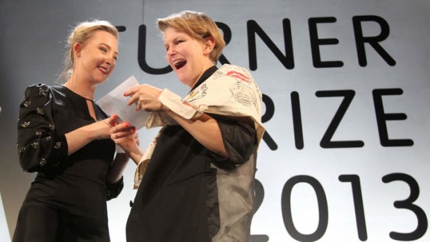French artist Laure Prouvost (R) reacts on stage with presenter Irish actress Saoirse Ronan (L) after she was announced as the winner of the 2013 Turner Prize for contemporary art.