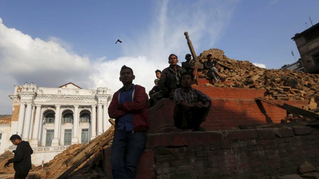 People sit on the rubble of a temple after the earthquake in Kathmandu.
