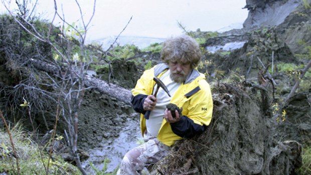 Scientist Sergei Zimov tests a sample of ground taken from a layer of melting permafrost in Siberia.