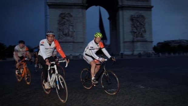 In Cadel's tyreprints: Tony Abbott (right) tackles the cobbles on the Champs-Elysees last weekend. The Prime Minister has been getting in the rides during his overseas tour.