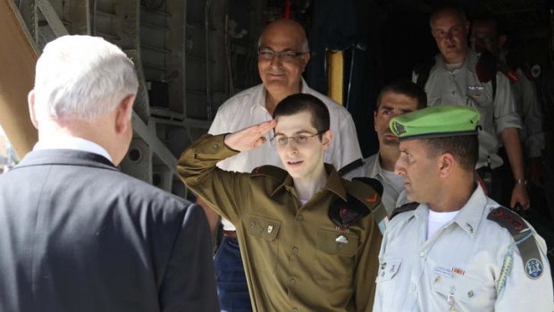 Gilad Shalit salutes Israel's Prime Minister Benjamin Netanyahu upon his arrival at Tel Nof air base in central Israel.