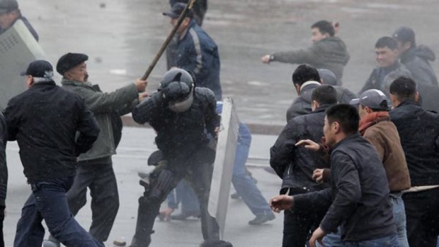 A protestor attacks a Kyrgyz policeman during clashes in Bishkek.