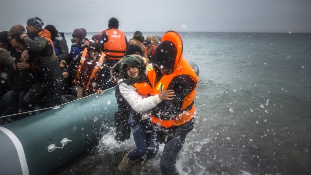Refugees and migrants disembark on  on the Greek island of Lesbos, after crossing from Turkey.
