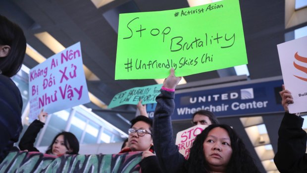 People from Asian community organisations in Chicago hold signs to protest after  the United incident.
