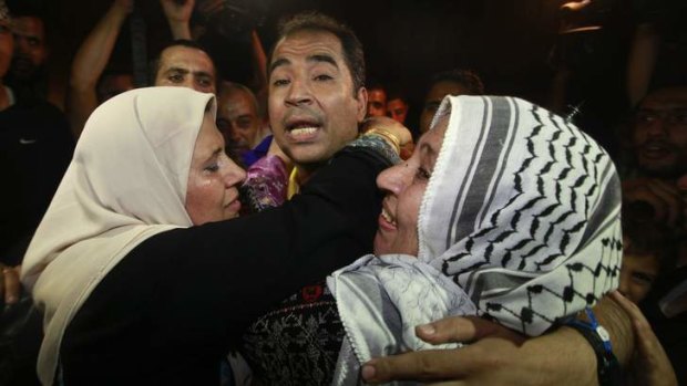 A freed Palestinian prisoner is hugged by his mother (right) upon his arrival near Erez Crossing, between Israel and northern Gaza Strip.