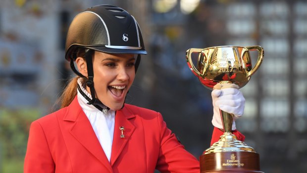 Model Rachael Finch holds up the Melbourne Cup trophy.
