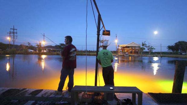 O'Neil Sevin, left, fishes with his son Stanley in the Bayou Petit Caillou in Chauvin, Louisiana.