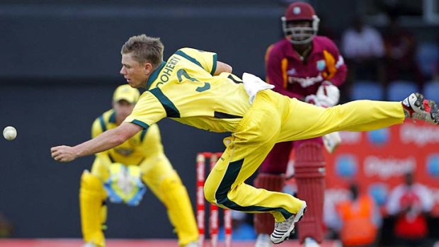 Australia spin bowler Xavier Doherty dives to intercept a shot off West Indies' captain Darren Sammy.