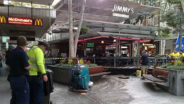 Workers try to clean up a smelly spill in Queen Street Mall.