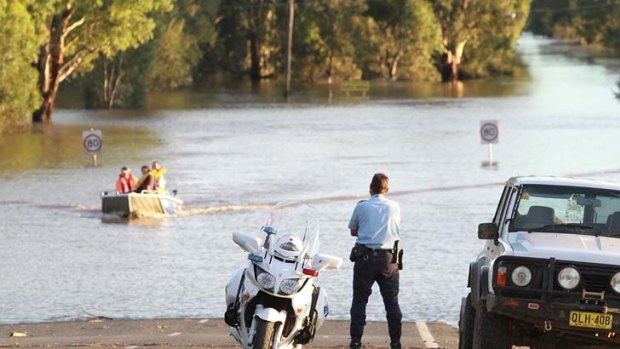 Devastating ... residents navigate flood waters near Wagga Wagga.