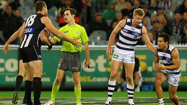 A field umpire remonstrates with Darren Jolly after a bump on Mathew Stokes (right) of the Cats.