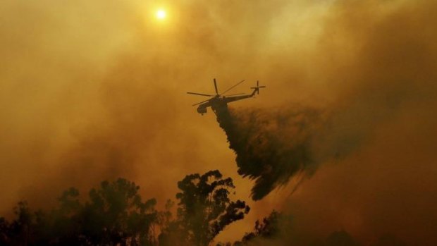 A firefighting helicopter drops water in Fallbrook, California.