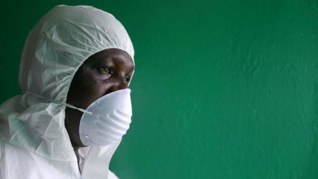 A health worker, wearing a protective suit, conducts an Ebola prevention drill at the port in Monrovia.