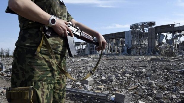 A pro-Russian militant stands guard in front of the destroyed Lugansk International Airport. 