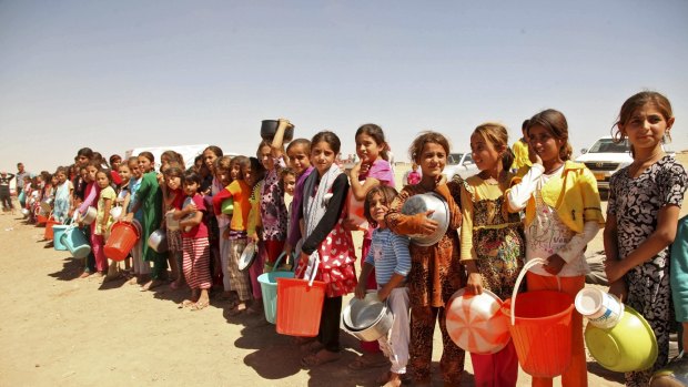 Yazidis fleeing violence in the Iraqi town of Sinjar west of Mosul last year line up for food. 