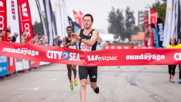 Liam Adams crosses the City2Sea finish line in first place just ahead of Dejen Gebreselassie.