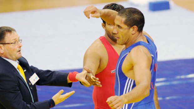 Australian wrestler Hassene Fkiri refuses to shake hands with India's Anil Kumar (obscured).