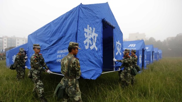 Safe havens: Chinese paramilitary policemen set up tents for quake victims on the grounds of a primary school in Yongping.