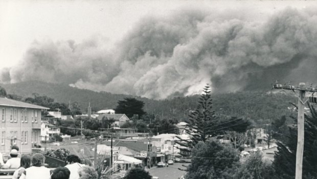 People on the balcony of Lorne Hotel watch as fire rolls over the Otway Ranges towards Lorne