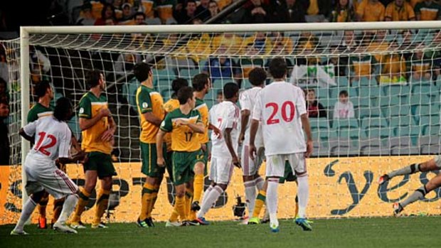 Stretching out: Socceroos goalkeeper Adam Federici makes a finger-tip save against Oman last night.