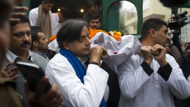 Shashi Tharoor, centre, helps carry his wife's body before her cremation.