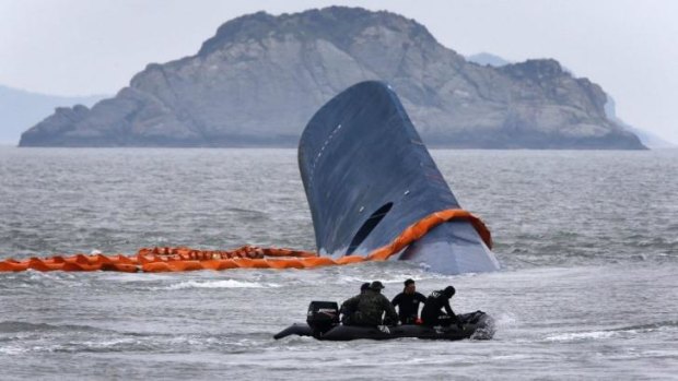A vessel involved in salvage operations passes near the upturned South Korean ferry Sewol.
