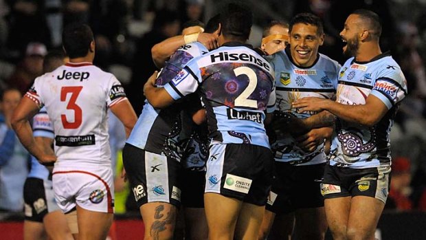 Meanwhile, on the field: The Sharks celebrate as they outplay the Dragons on Saturday.