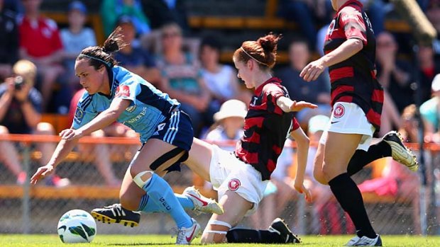Physical contest &#8230; Sydney FC's Emma Kete is brought down by the Wanderers defence.