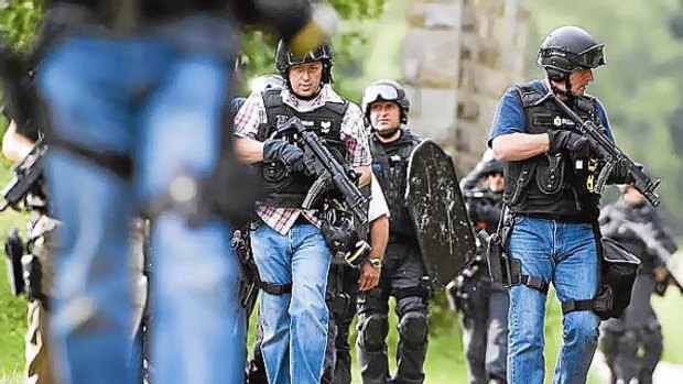Armed police can be seen in the woods surrounding Rothbury in the continued search for Raoul Moat, in Rothbury, northeast England. <i/>Photo: AFP/Derek Blair</i>
