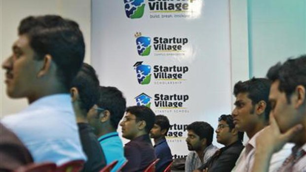 Entrepreneurs, employees and students listen to a speech.