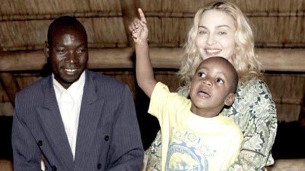 Madonna holds her adopted son David as they meet with the boy's biological father.