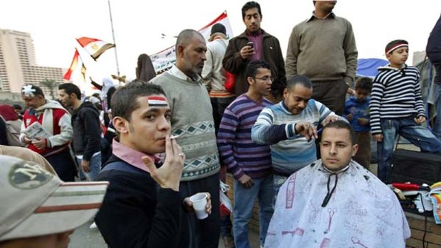 Keeping up appearances ... a protester has his hair cut during the continuing demonstrations in Tahrir Square in Cairo. The protesters have dug in for the long haul.