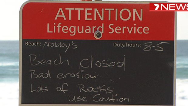 A sign at Nobby's Beach advising it was closed this morning.