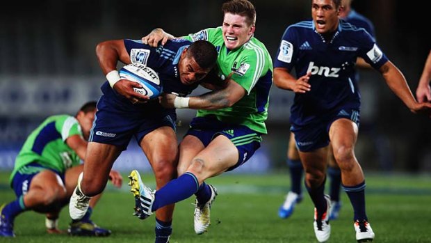 George Moala of the Blues fends off Colin Slade of the Highlanders.