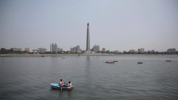 North Koreans row boats on the Taedong River against a backdrop of the Juche Tower named after the state ideology of self-reliance, introduced by the nation's founder Kim il-sung.