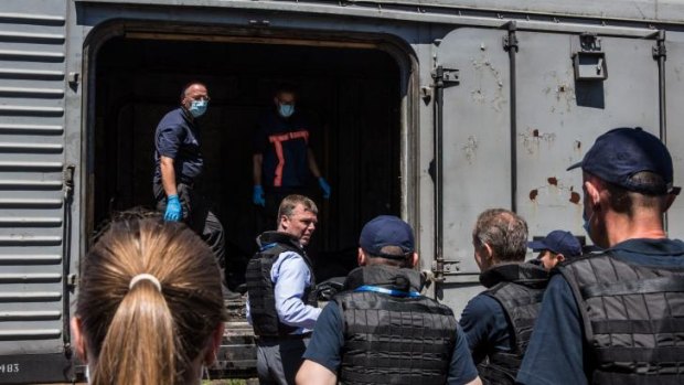 Alexander Hug (centre), Deputy Chief Monitor of the Organisation for Security and Cooperation in Europe (OSCE) Special Monitoring Mission to Ukraine, visits a train containing the bodies of victims of the Malaysia Airlines flight MH17 crash in Torez. 