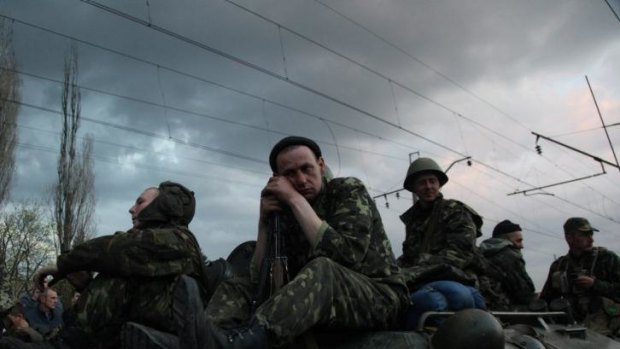 Ukrainian soldiers sit on armoured vehicles as they are blocked by pro-Russian supporters.