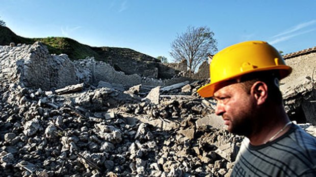 A worker inspects the ruins of the House of the Gladiators.