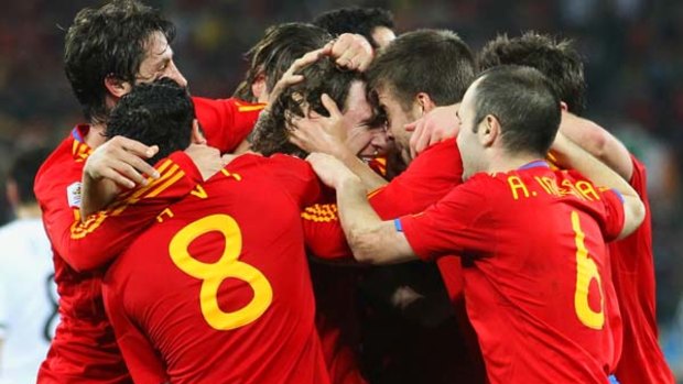Through to the final ... Spain players mob Carles Puyol, centre, after he scored the only goal of the match.