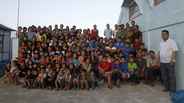 Hard to remember birthdays ... sect leader Ziona Chana (right), 70, poses with his family for a group photograph outside their residence in the mountain village of Baktawng in the northeastern Indian state of Mizoram in 2011. 