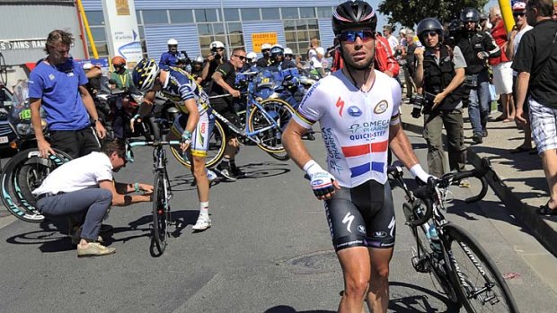 Angry:  Mark Cavendish of Britain walks with his bicycle after he fell off.