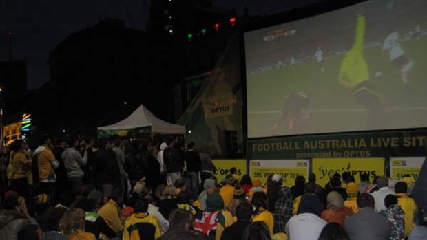 Australia and Germany fans huddle together in the early morning cold at Reddacliff Place to watch last week's opening World Cup match.