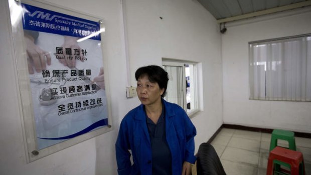 Gao Ping, a worker in the alcohol prep pads division, leaves a room after speaking to journalists inside the Specialty Medical Supplies plant, where American Chip Starnes is being held hostage.